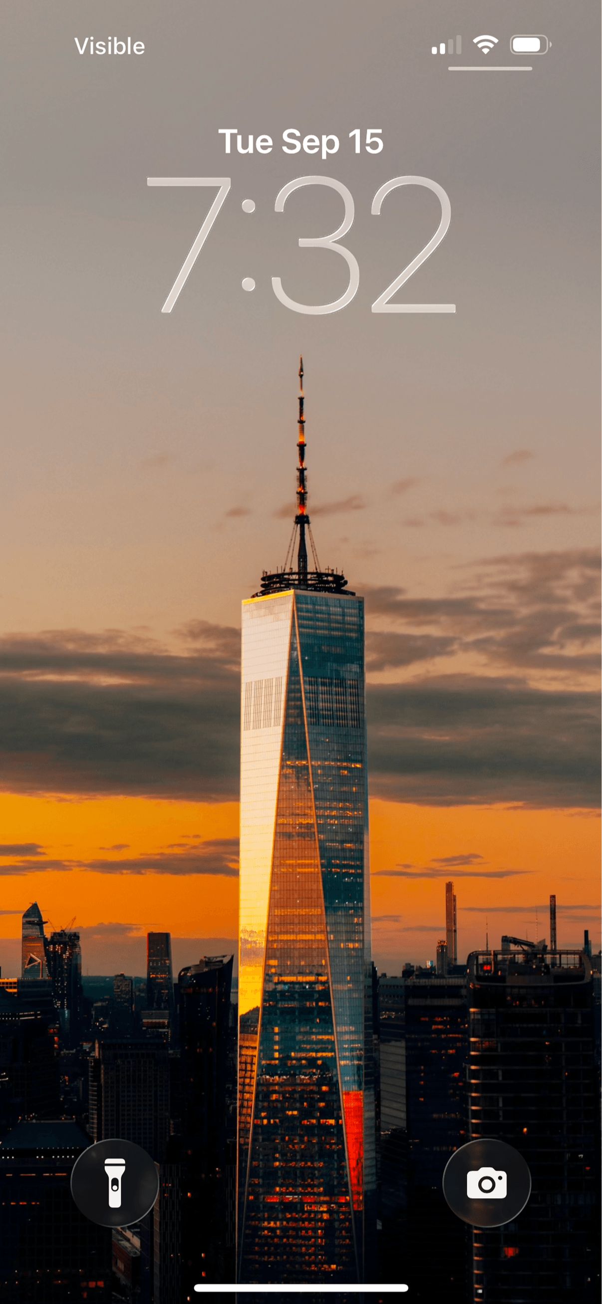 A lock screen showing the One World Trade Center at sunset